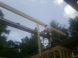 Carpenter setting a ridge beam over a new addition frame — Ice Dam Removal by Roofing Brothers in Clarkfield