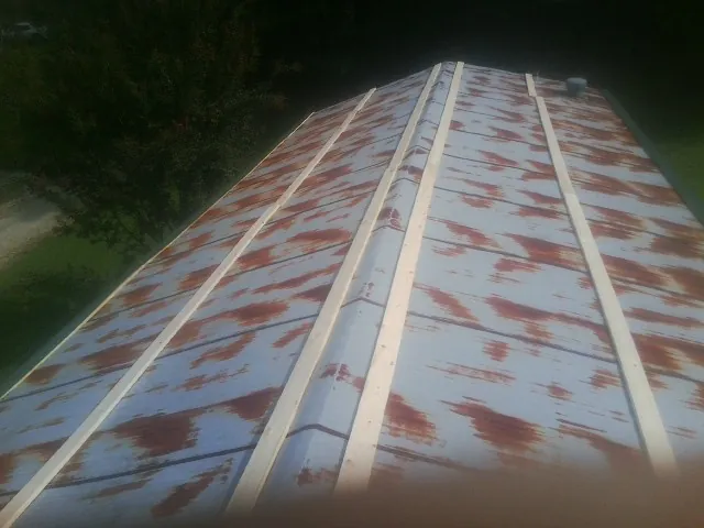 Rusted metal roof panels with new wood purlins before replacement — Storm Damage Roof Repair in Clarkfield by Roofing Brothers
